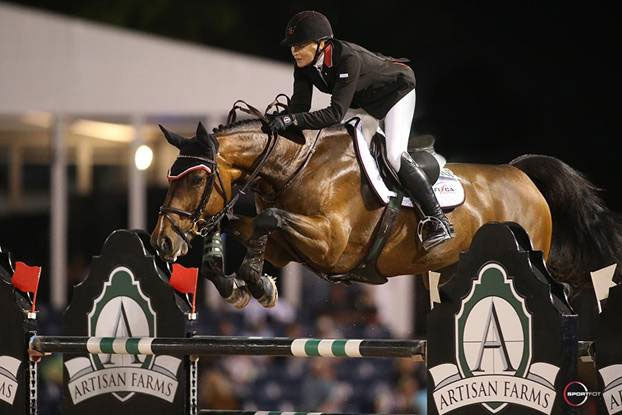 Nina Fagerstrom on dark bay horse clearing a high oxer showing jumping fence.