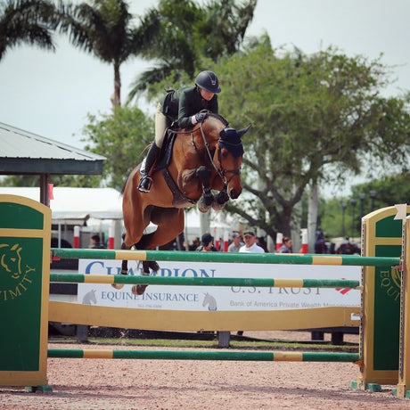 Lillie Keenan riding a bay horse over an oxer.